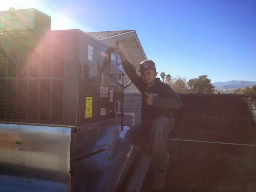 HVAC technician performing AC Tune-Up on a rooftop unit in Billings